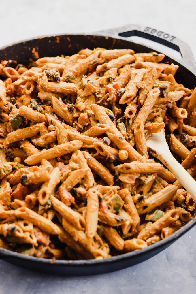 a cast iron skillet of Mexican-inspired pasta with corn, black beans and peppers