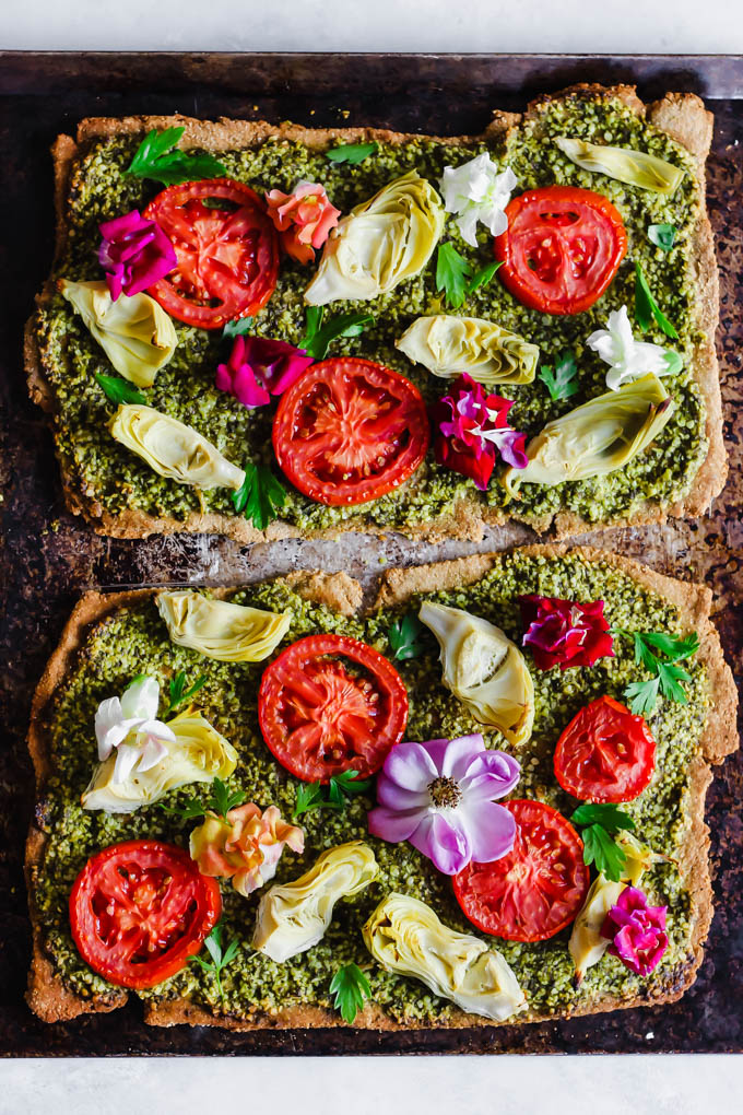 Impress your dinner party guests with this beautiful Floral Tomato & Artichoke Pesto Flatbread! This appetizer only requires 30 minutes to make & is full of flavor. (vegan)