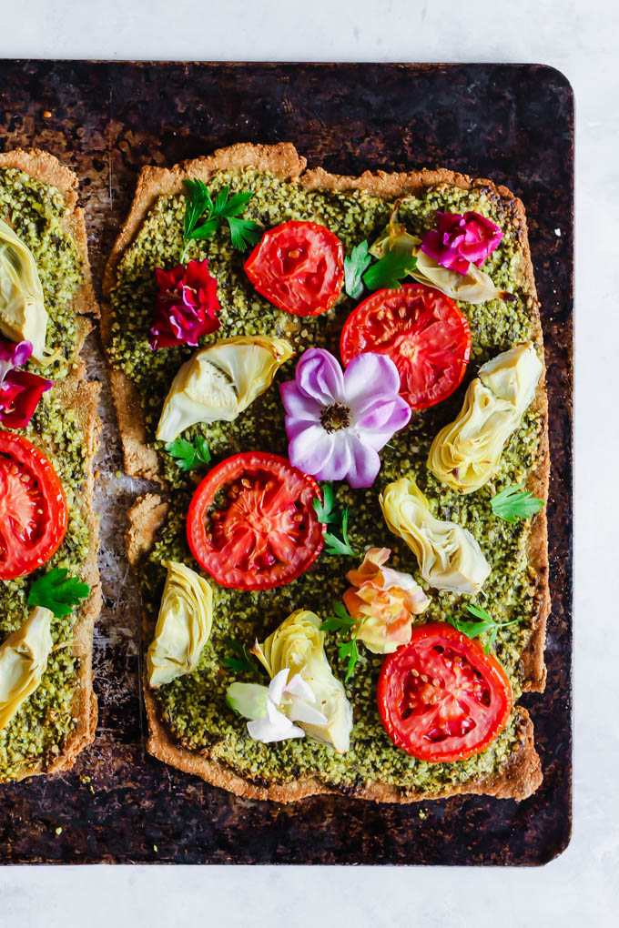 Impress your dinner party guests with this beautiful Floral Tomato & Artichoke Pesto Flatbread! This appetizer only requires 30 minutes to make & is full of flavor. (vegan)