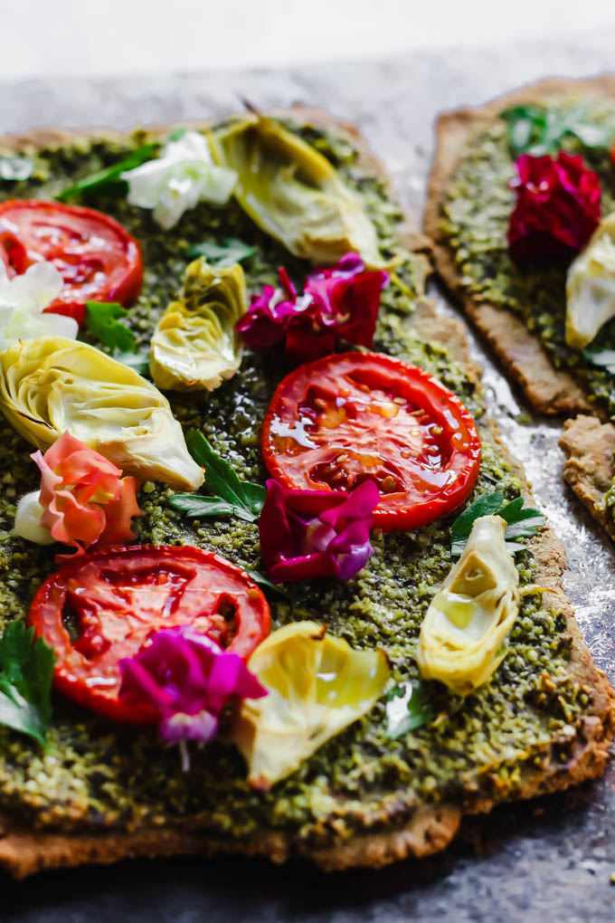 Impress your dinner party guests with this beautiful Floral Tomato & Artichoke Pesto Flatbread! This appetizer only requires 30 minutes to make & is full of flavor. (vegan)