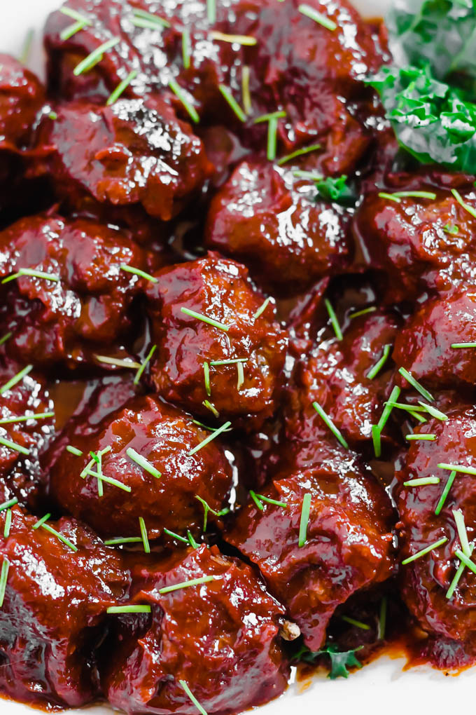 a bowl of meatballs topped with barbecue sauce