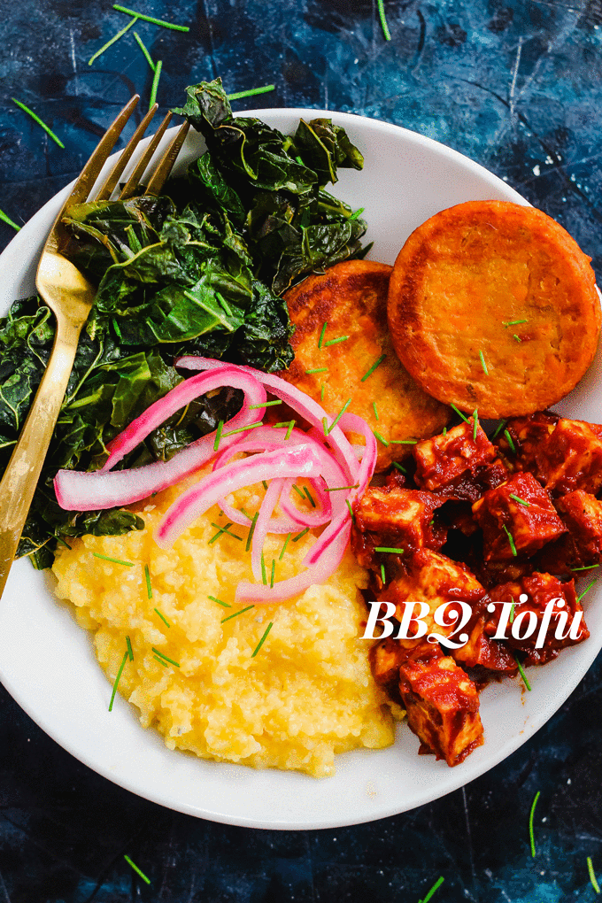a bowl filled with collard greens, sweet potato slices, tofu, grits and picked onions