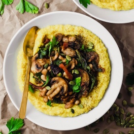 a bowl of polenta topped with vegetables