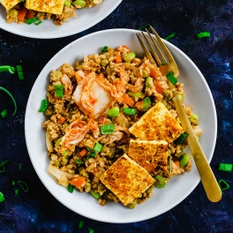 A bowl of vegan kimchi fried rice topped with green onions