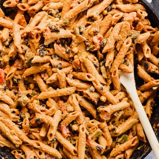 a cast iron skillet filled with pasta and veggies