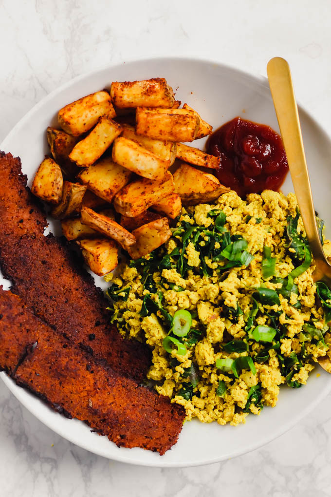 This loaded Vegan Breakfast Plate is the ultimate weekend brunch! It features eggy tofu scramble, veggie bacon, and crispy roasted potatoes.
