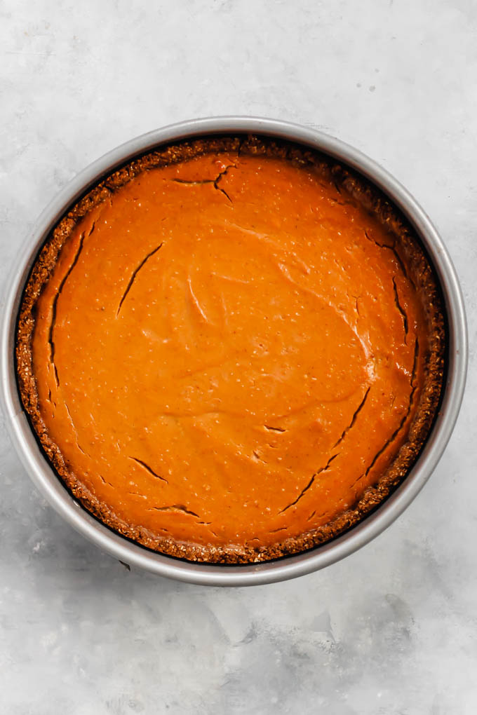 a full vegan pumpkin cheesecake resting in a springform pan