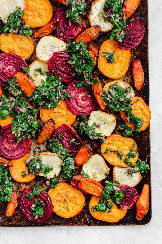 a tray of thinly sliced root vegetables topped with herbs
