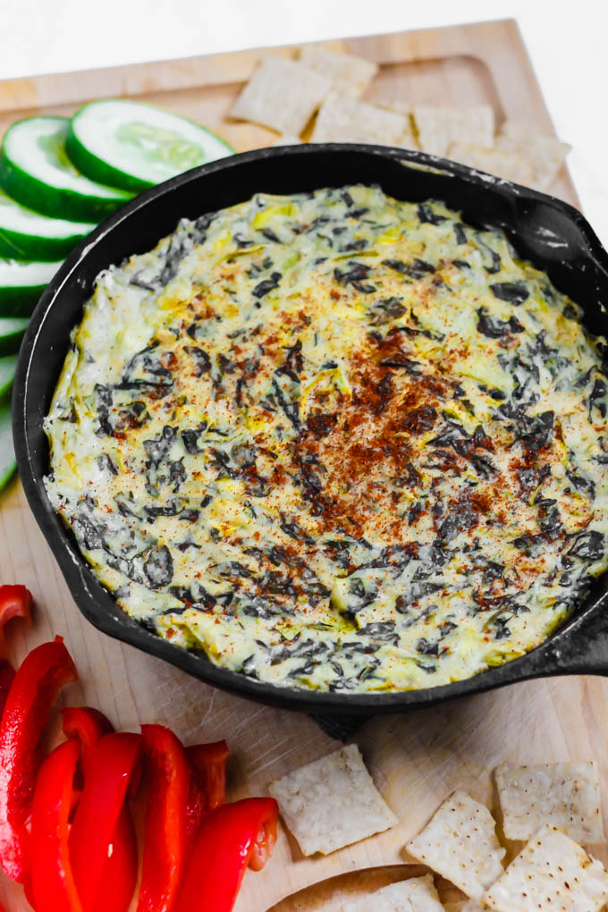 a cast iron skillet full of vegan spinach artichoke dip