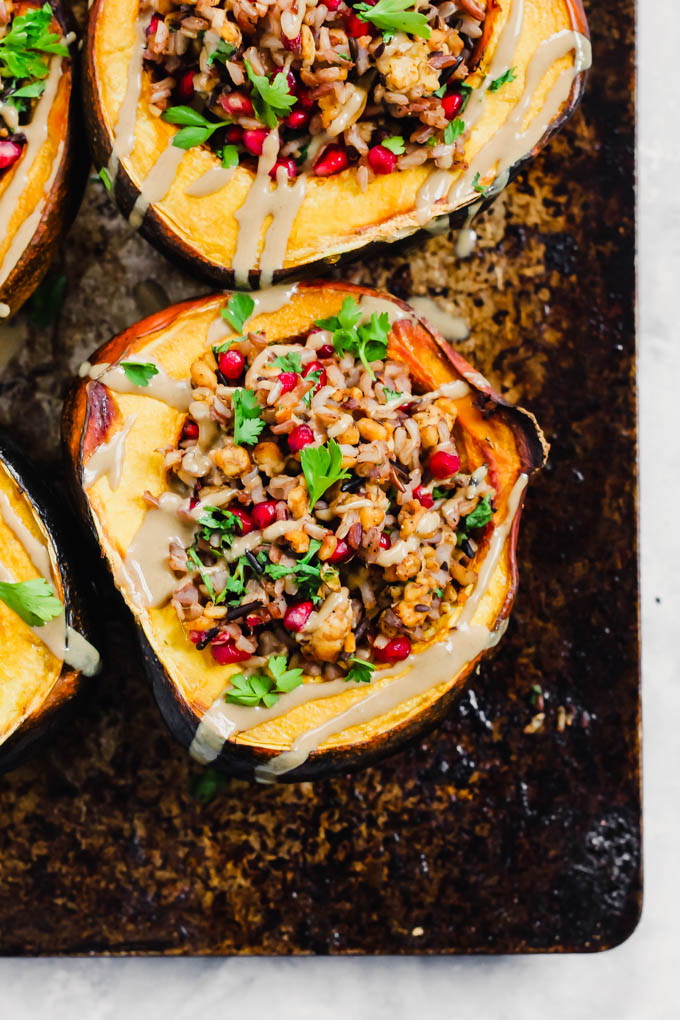 an acorn squash sliced in half and stuffed with tempeh and wild rice