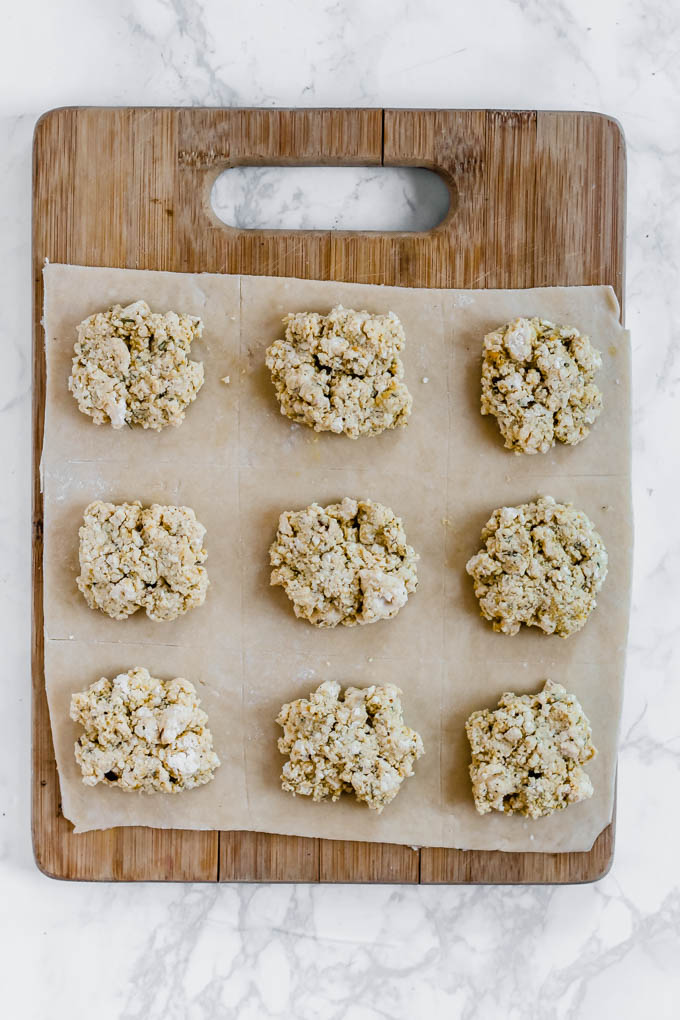 a sheet of pasta dough with nine dollops of vegan ricotta filling spaced evenly on top