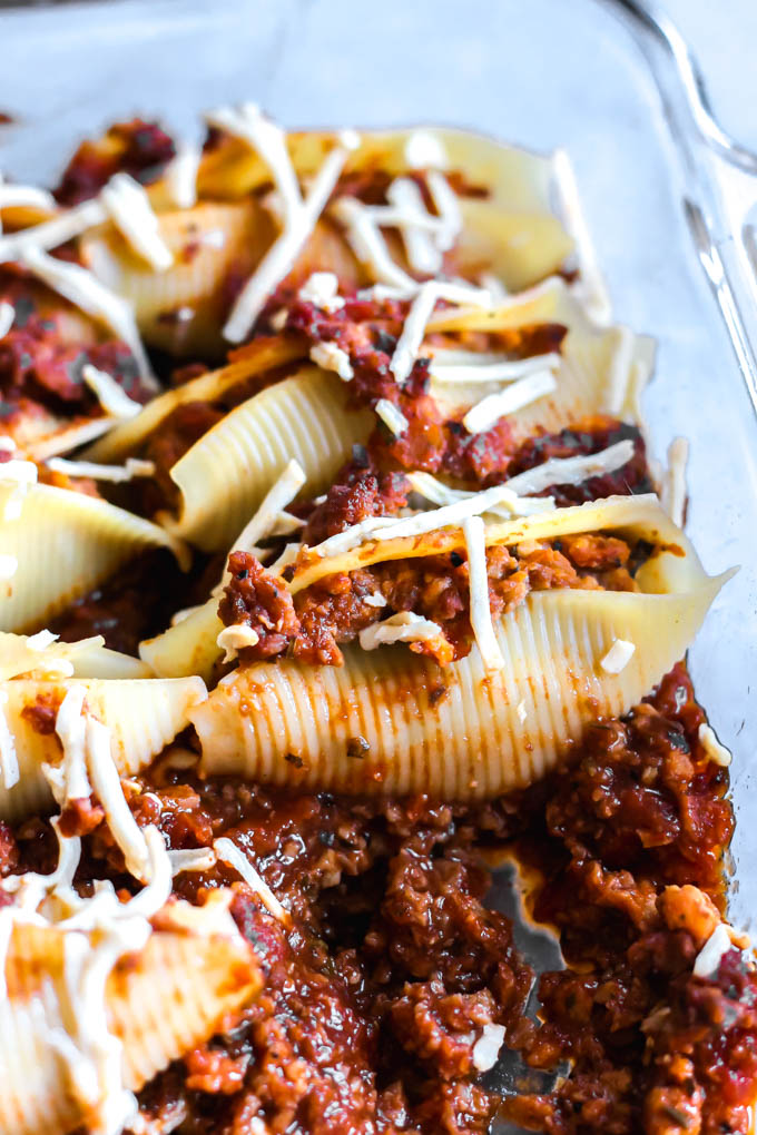 a dish of stuffed jumbo shells topped with vegan mozzarella