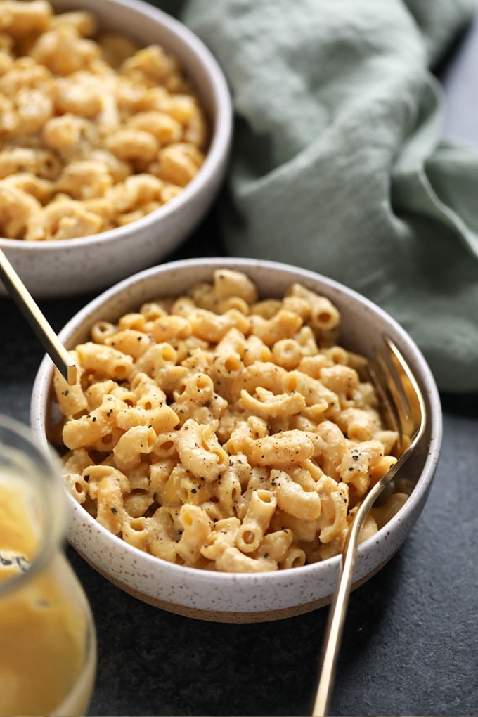 A fork digging into a bowl of vegan mac and cheese