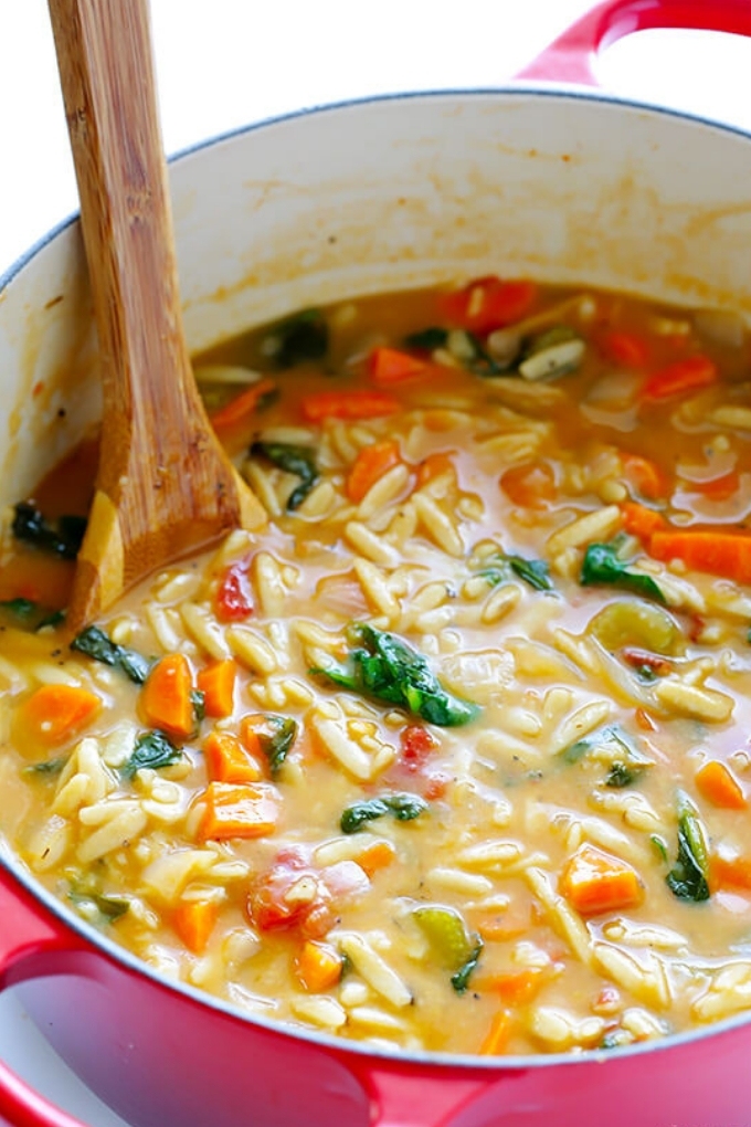 A red pot filled with Italian orzo soup