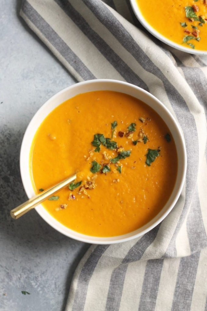 A white bowl filled with vegan carrot ginger soup