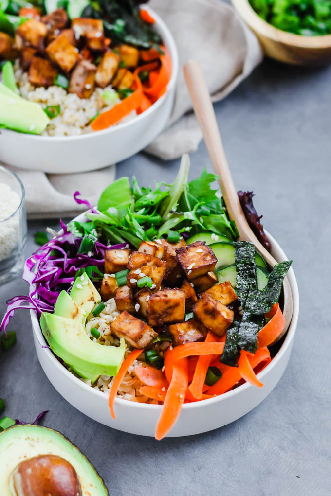 a vegan poke bowl made with tofu, sliced veggies and greens