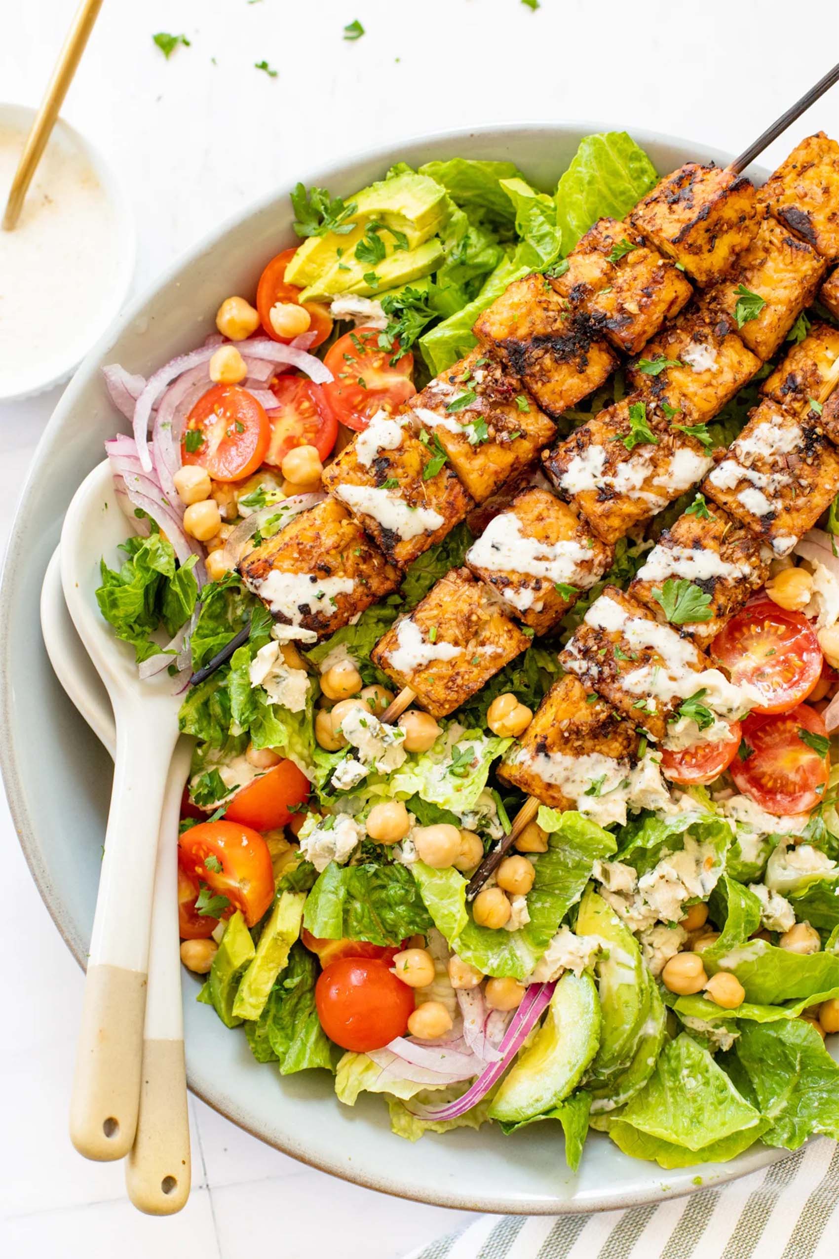 grilled tempeh skewers served on a greek salad