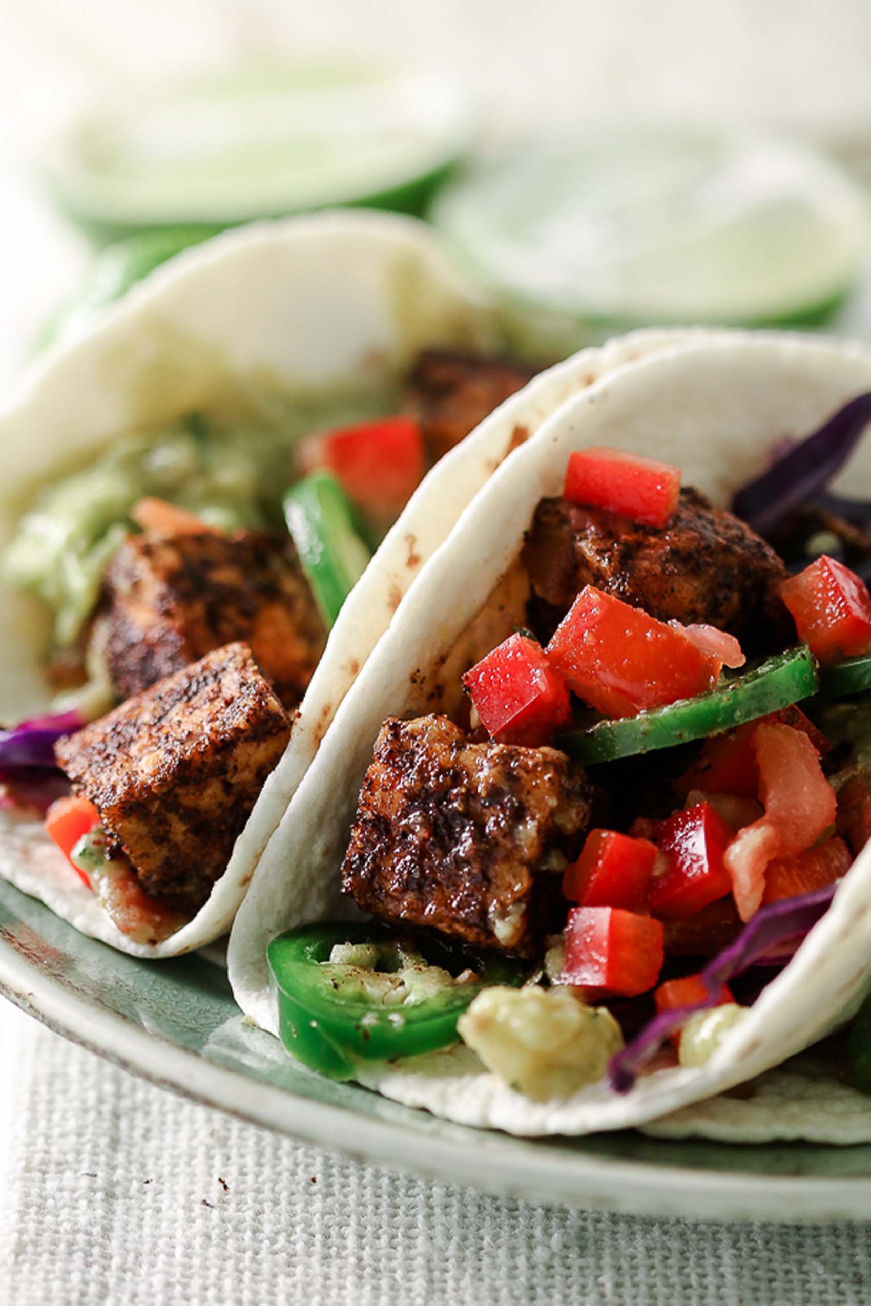 two vegan tempeh tacos on a plate served with veggies