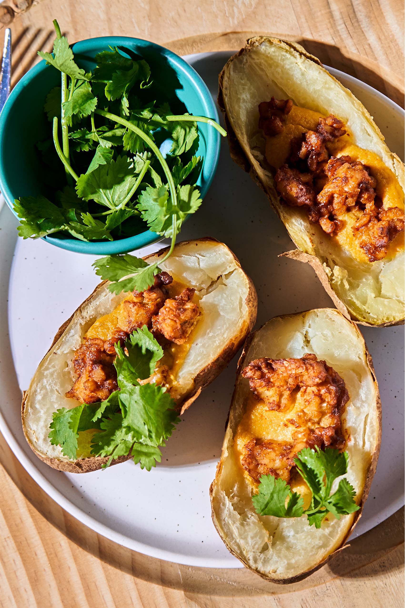 a plate of vegan tempeh baked potato skins topped with cilantro