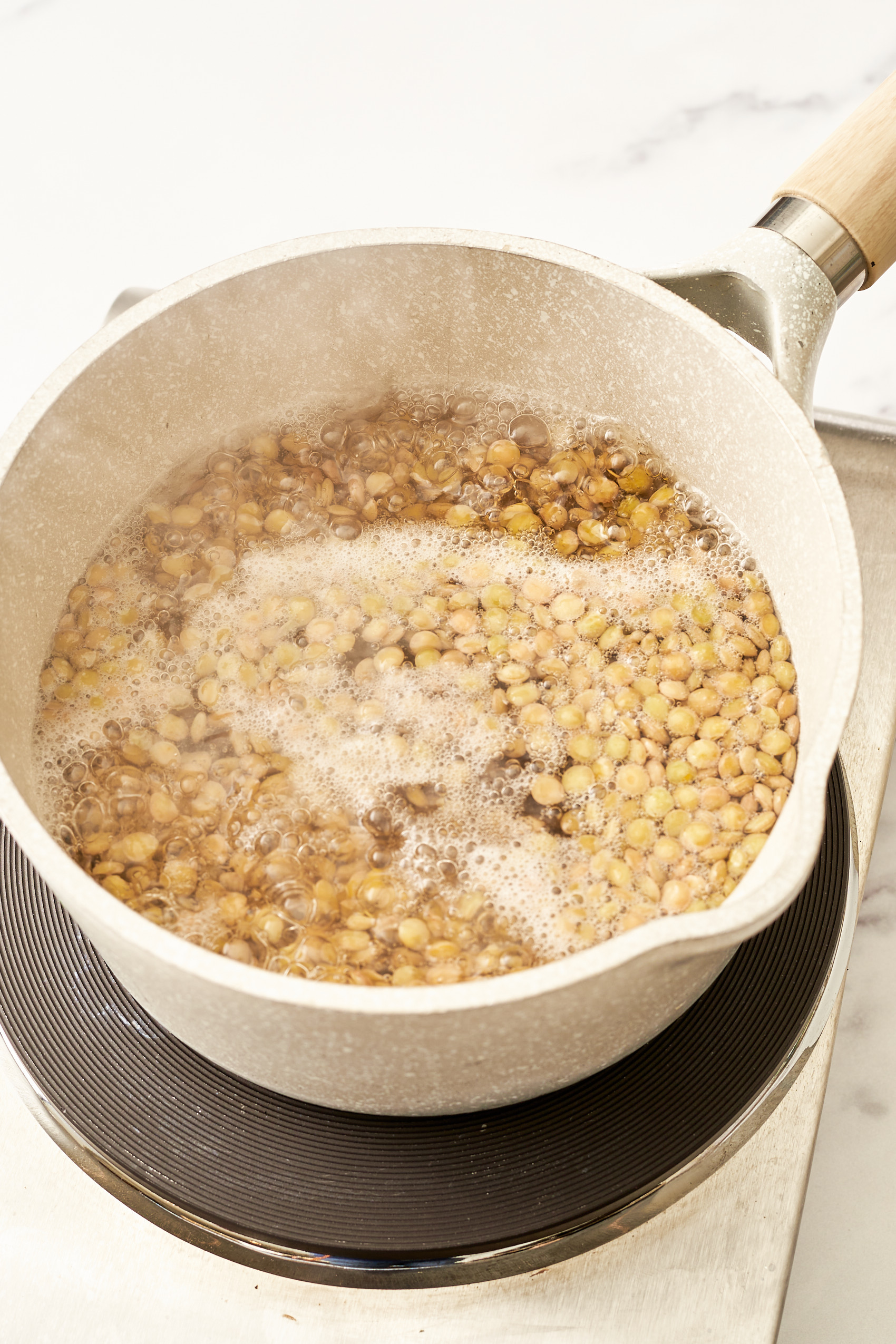 a pot of green lentils boiling on the stove