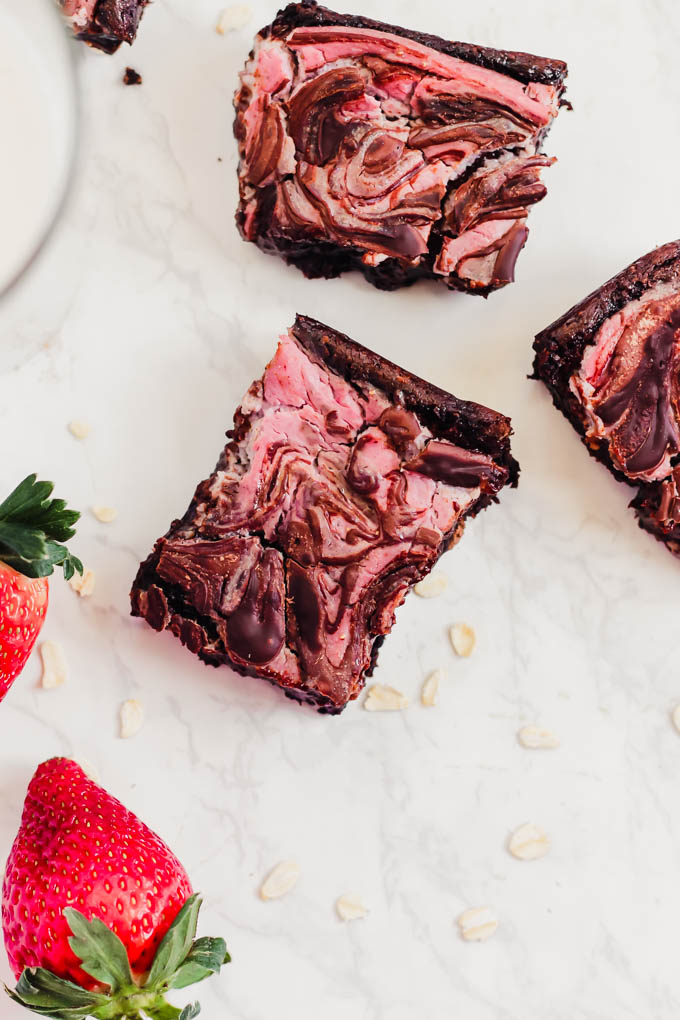 a batch of strawberry brownies surrounded by fresh strawberries
