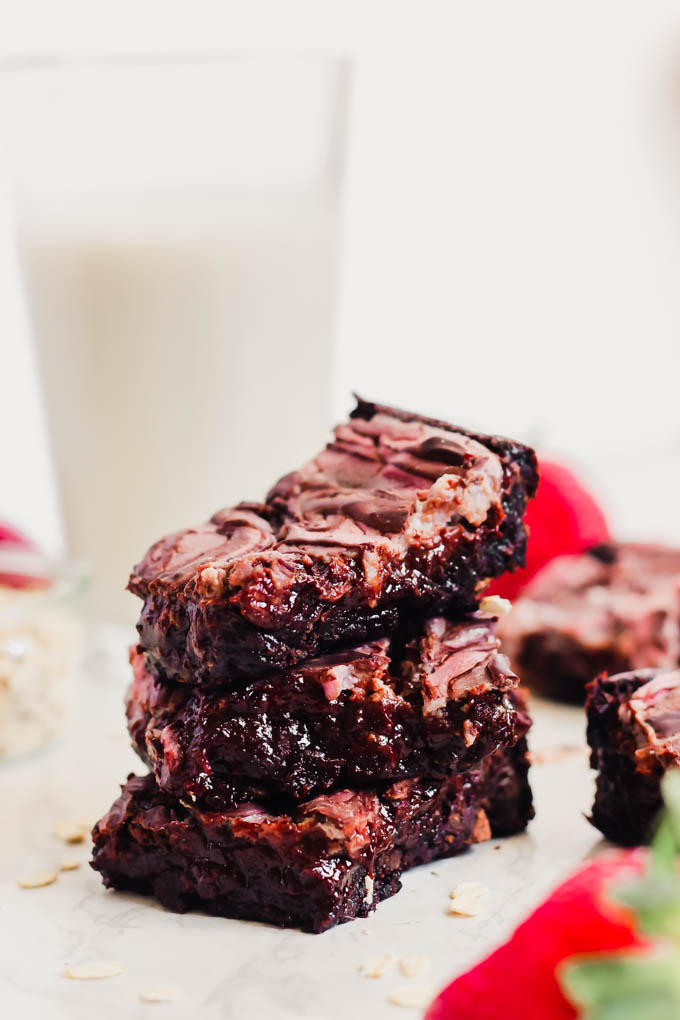 a stack of sliced strawberry cheesecake brownies