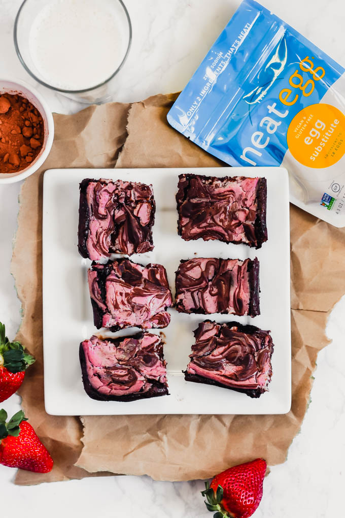 a plate of vegan strawberry brownies next to a bag of neat egg
