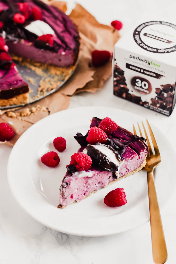 a slice of dairy free raspberry cheesecake topped with chocolate