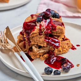 a plate of sweet potato waffles topped with blueberry sauce