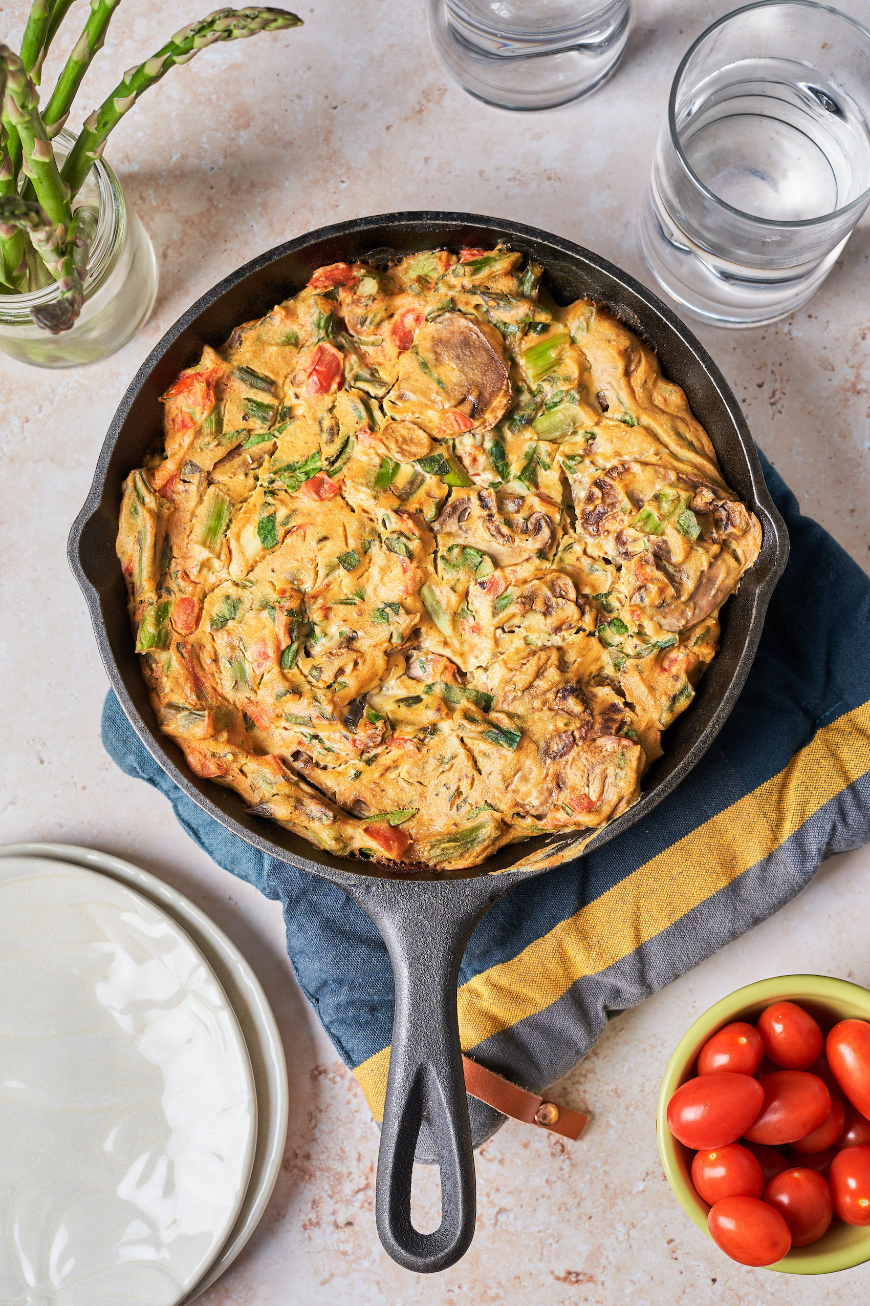 a cast iron skillet holding a vegan mushroom and asparagus quiche