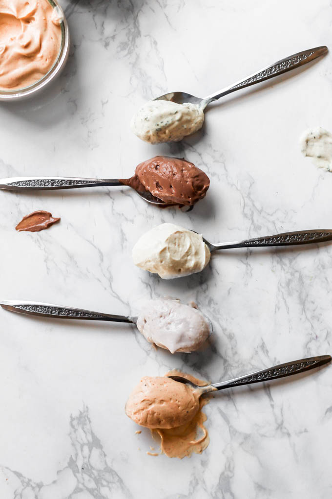 5 spoons each holding a different flavor of homemade vegan cream cheese