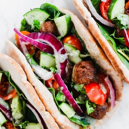 a vegan beef gyro topped with tzatziki