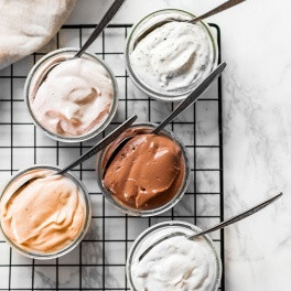 a collection of 5 vegan cream cheeses including plain, strawberry, chocolate, spicy and garlic and herb