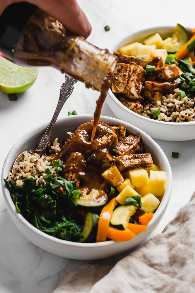 a jerk marinade is poured over a tofu power bowl