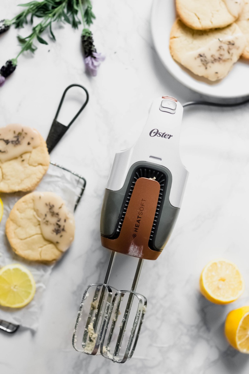 an Oster hand mixer alongside a plate of lemon cookies