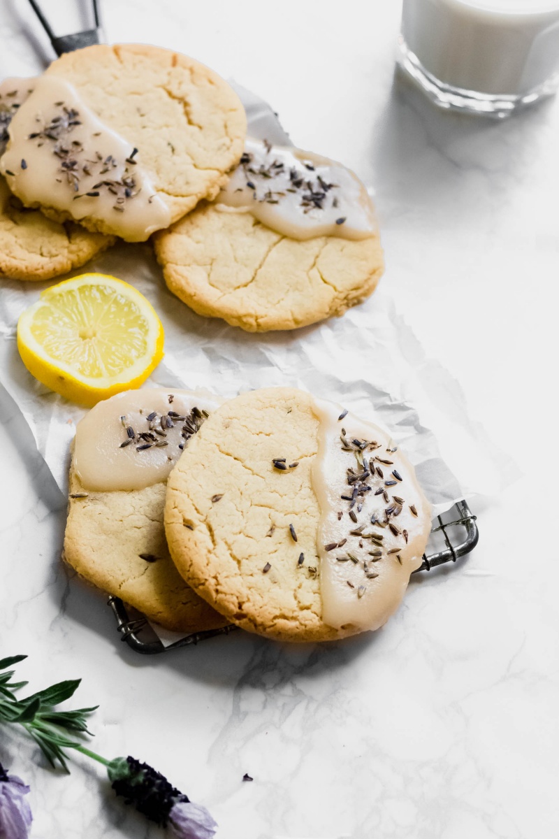 a plate of vegan lavender lemon cookies served alongside a glass of vegan milk