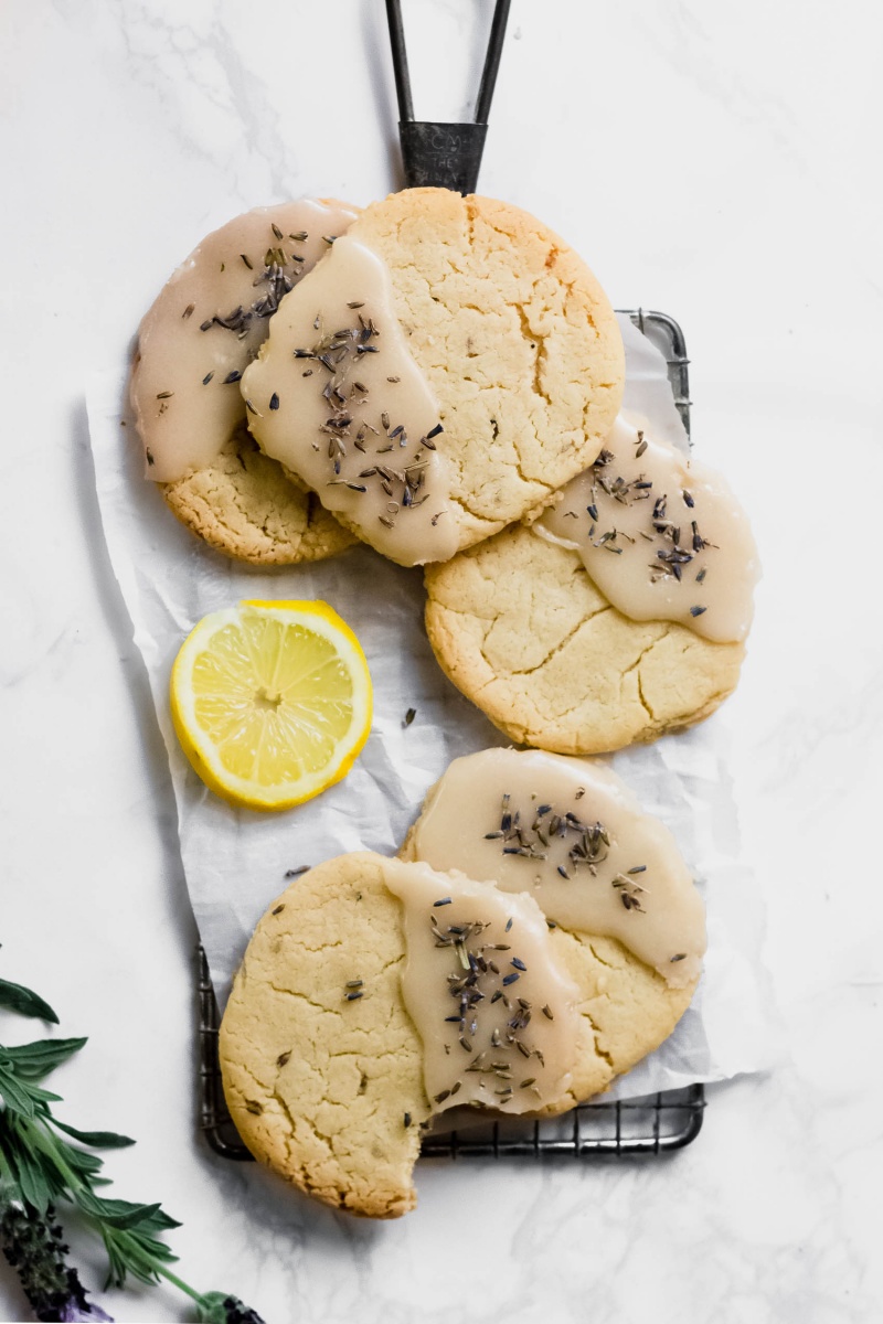 A tray of lavender lemon cookies, one with a bite taken out of it