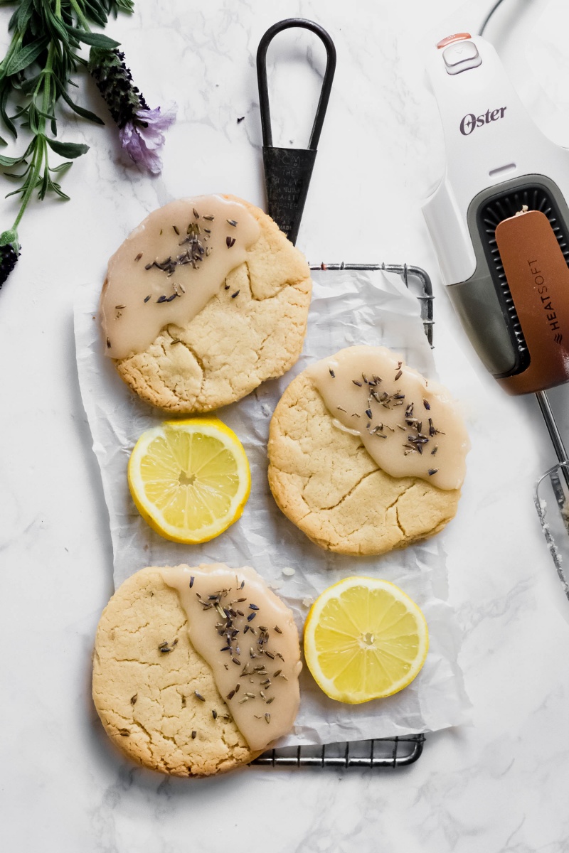 a tray of three lavender lemon cookies served alongside lemon slices