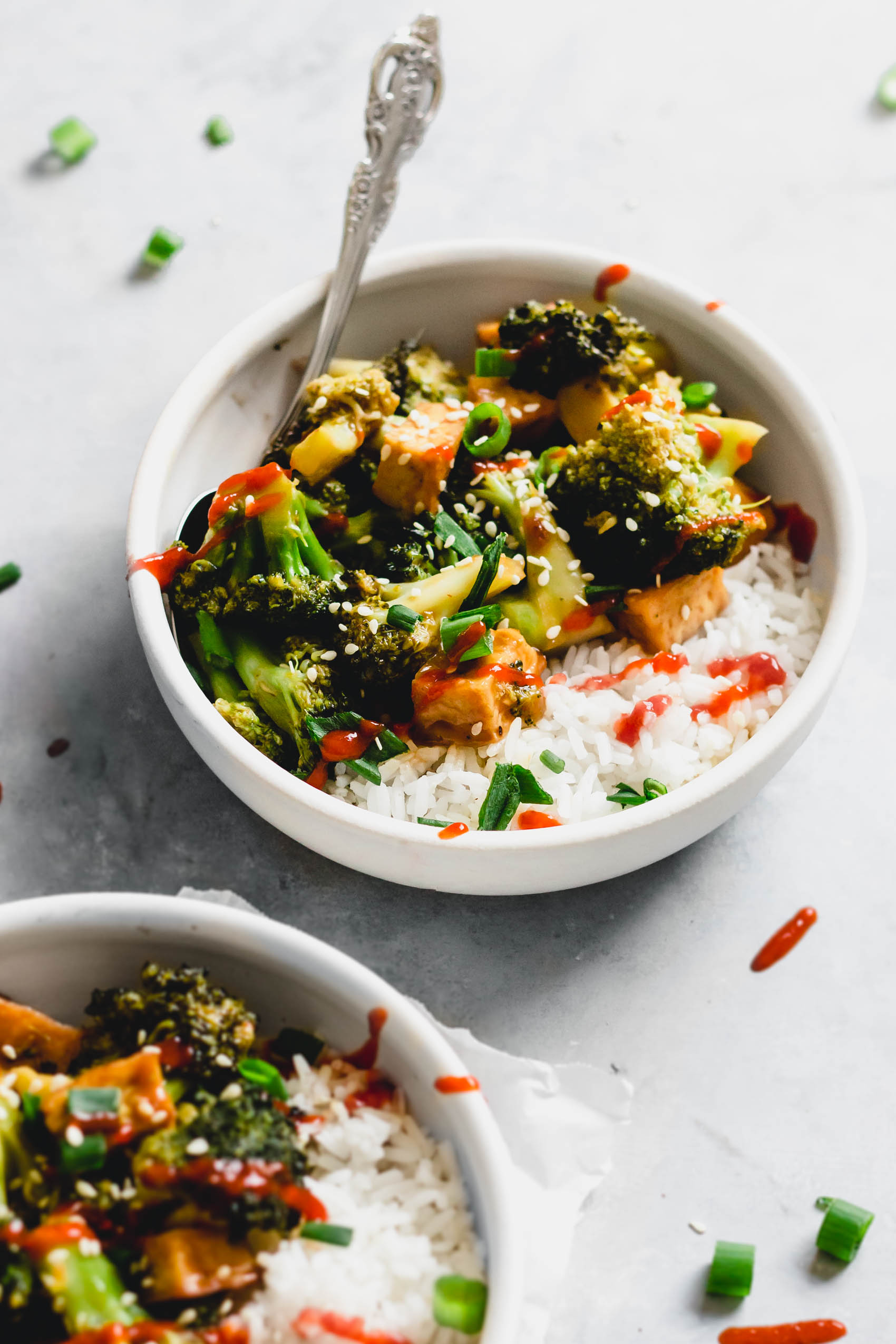 two bowls of tofu and broccoli stir fry over white rice