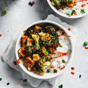 two bowls of tofu and broccoli stir fry served over white rice