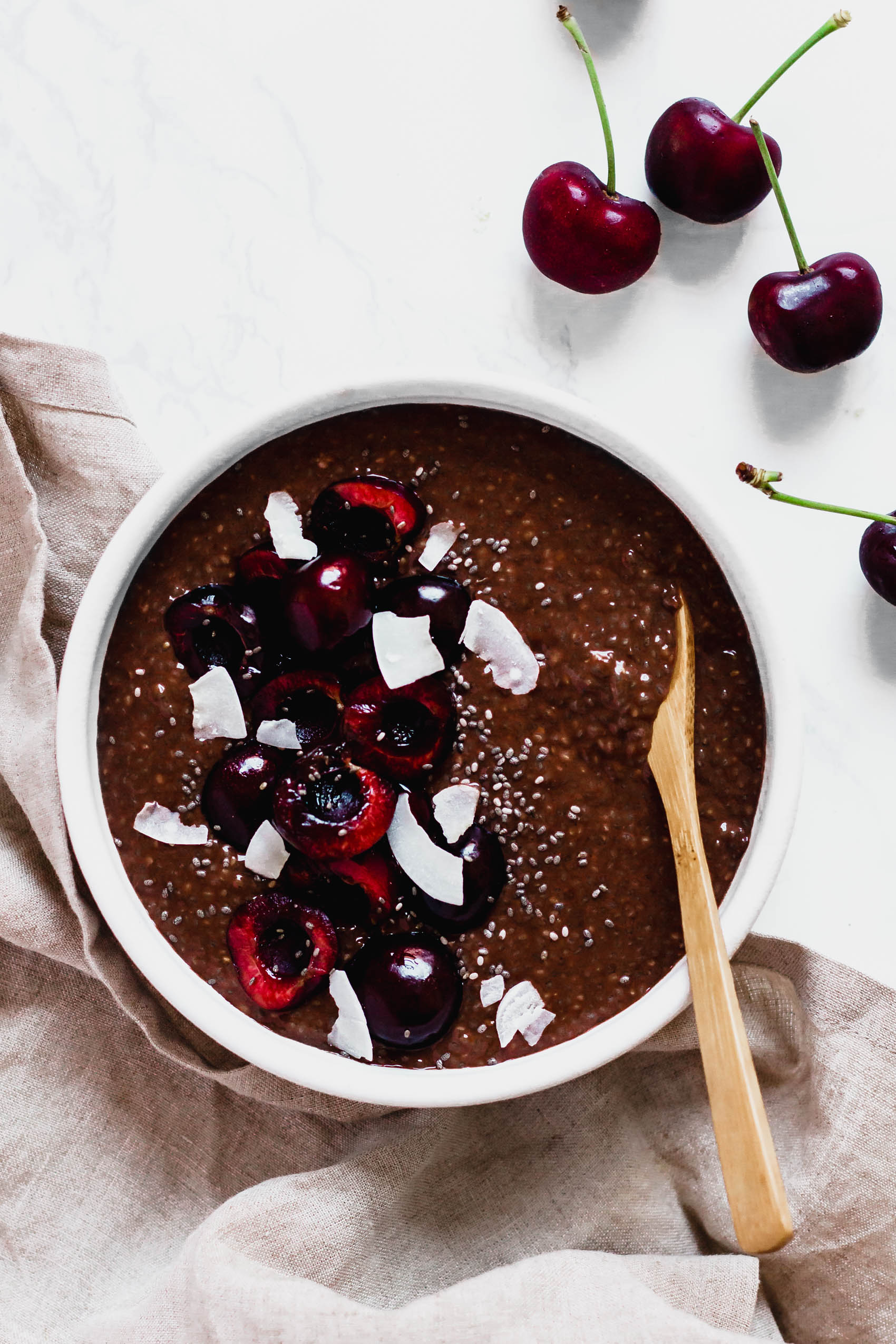 a spoon scooping into a bowl of chocolate cherry chia pudding