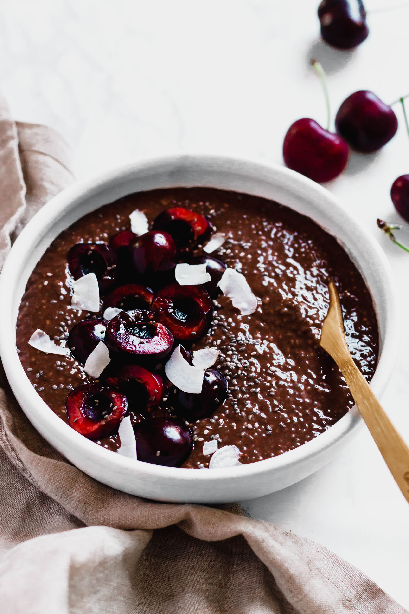 a bowl of dark chocolate cherry chia pudding topped with coconut