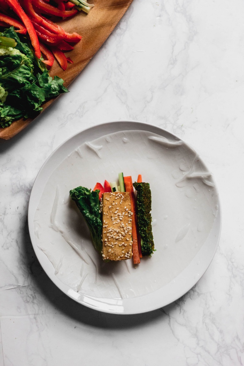 A sheet of rice paper with tofu and veggies laid on top