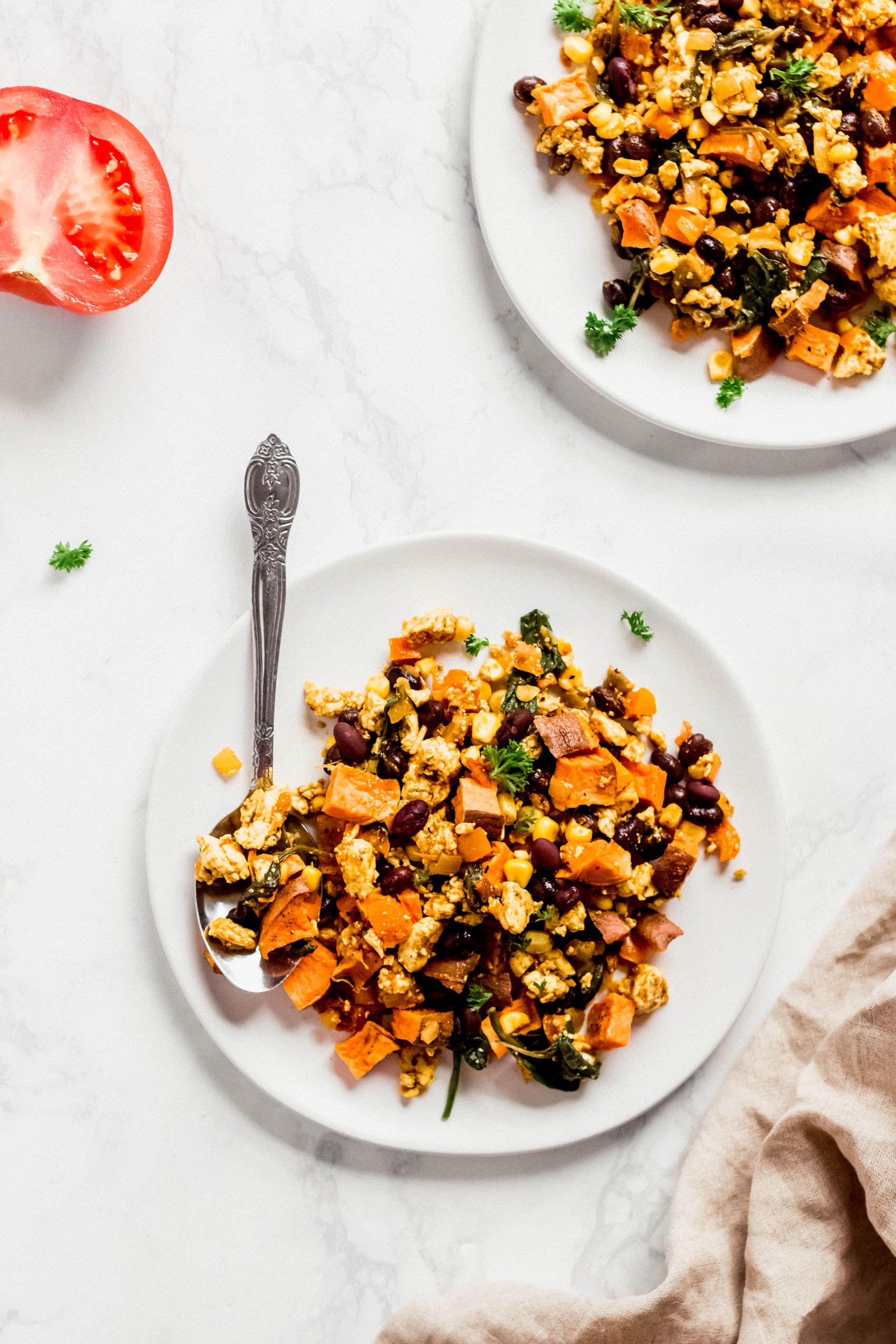 a plate of tofu scramble with sweet potato, black beans and tomatoes