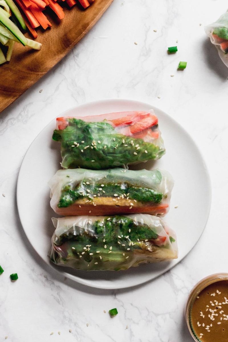 an overhead shot of three vegetable spring rolls served on a white plate