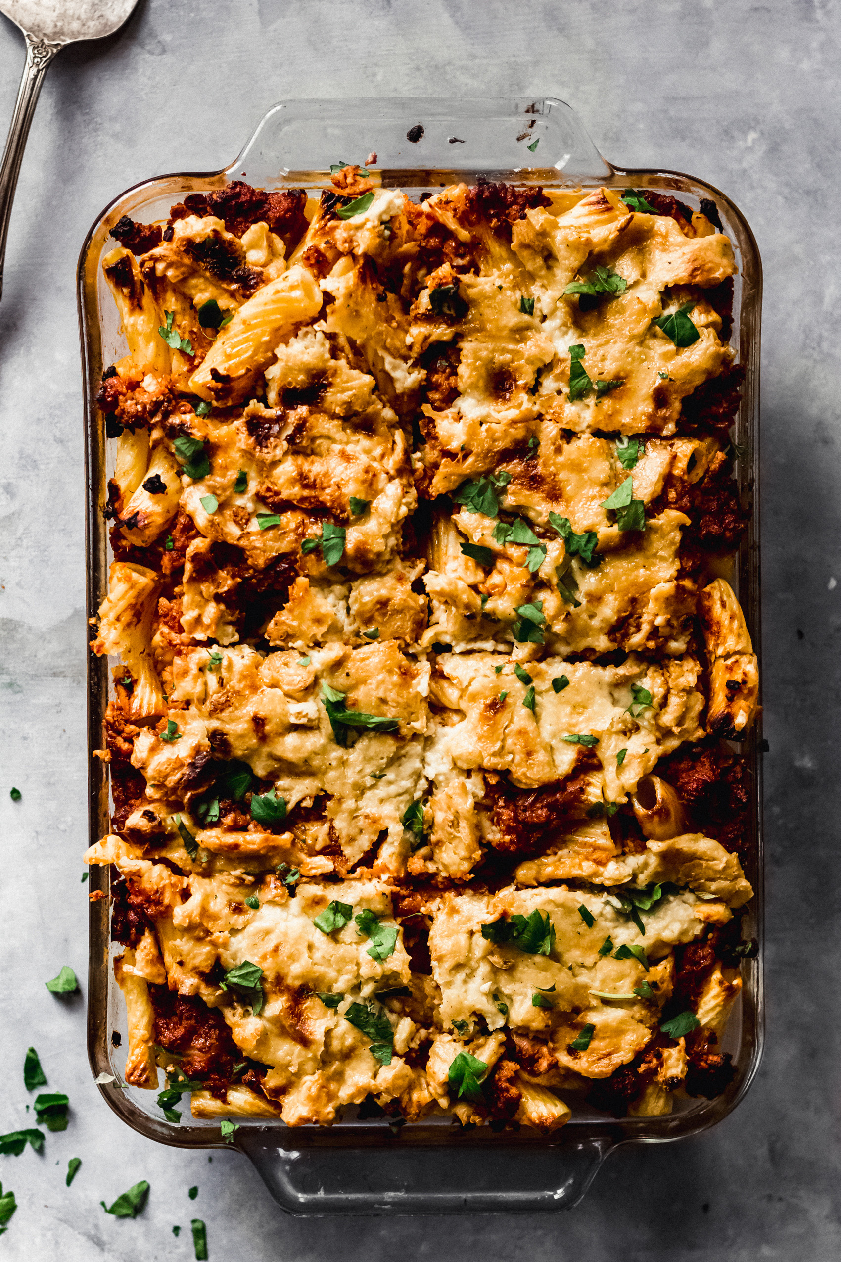 a casserole dish filled with vegan baked ziti cut into 8 slices