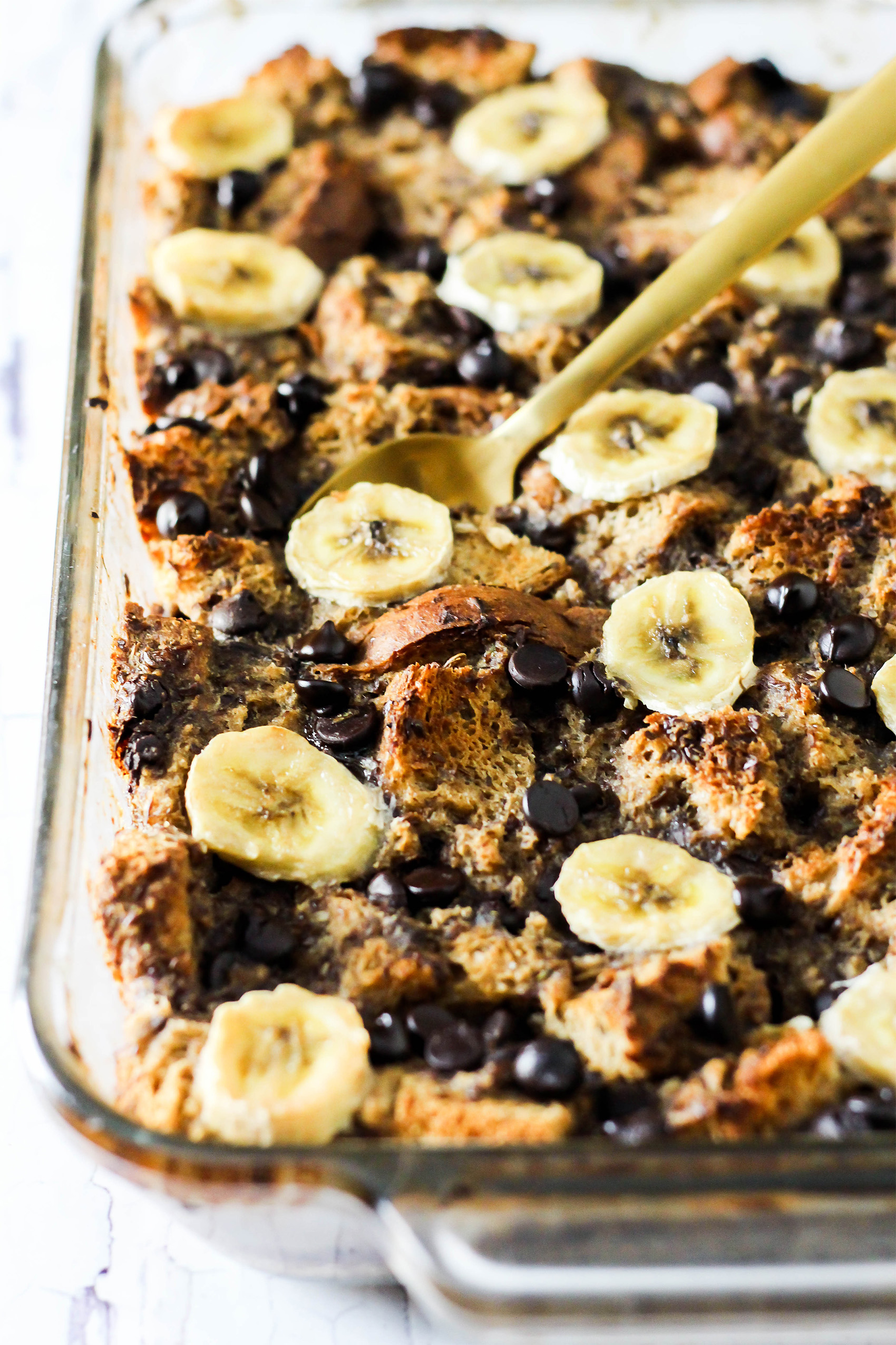 a dish of french toast casserole topped with banana slices and berries