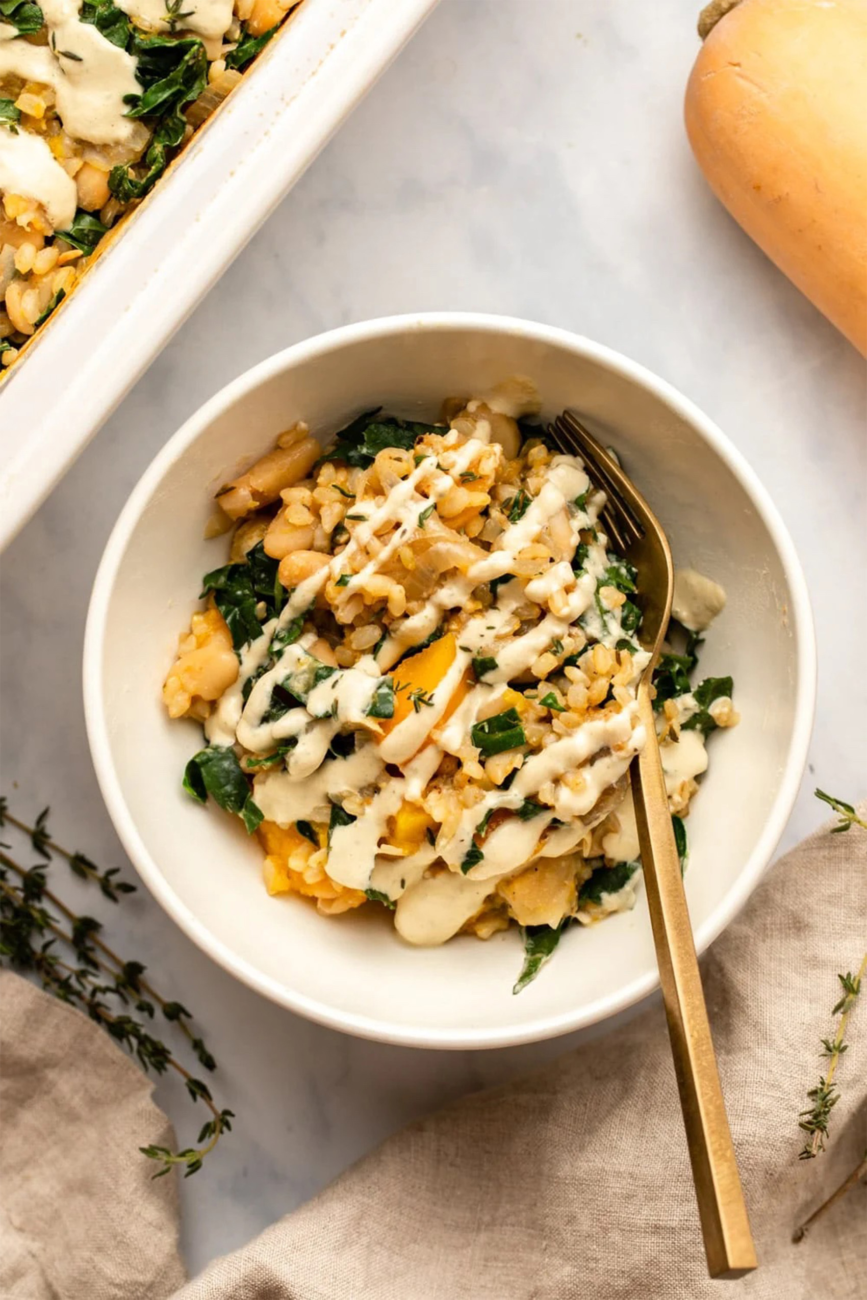 a spoon digging into a bowl of vegan butternut squash casserole