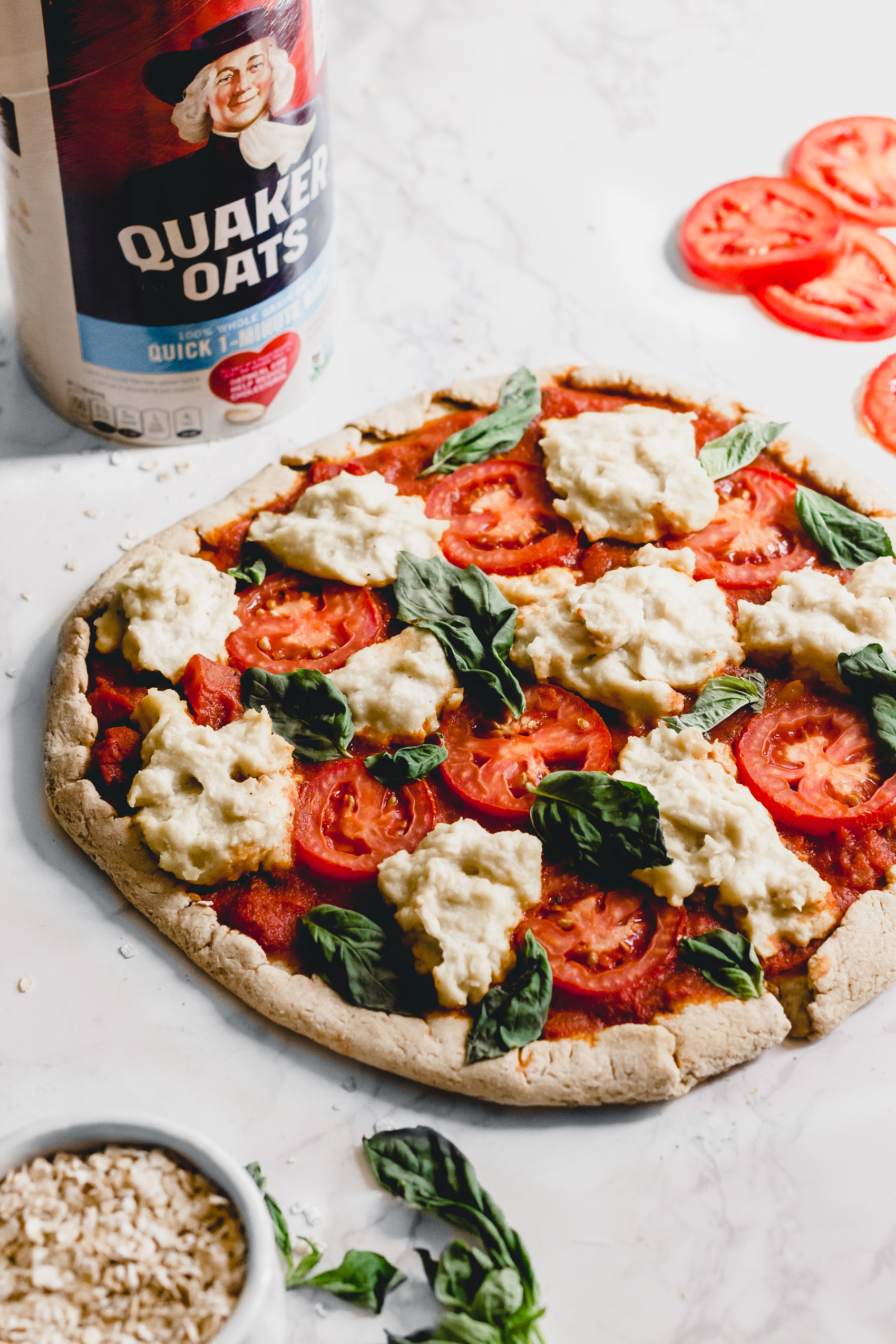a homemade vegan pizza next to a container of Quaker oats