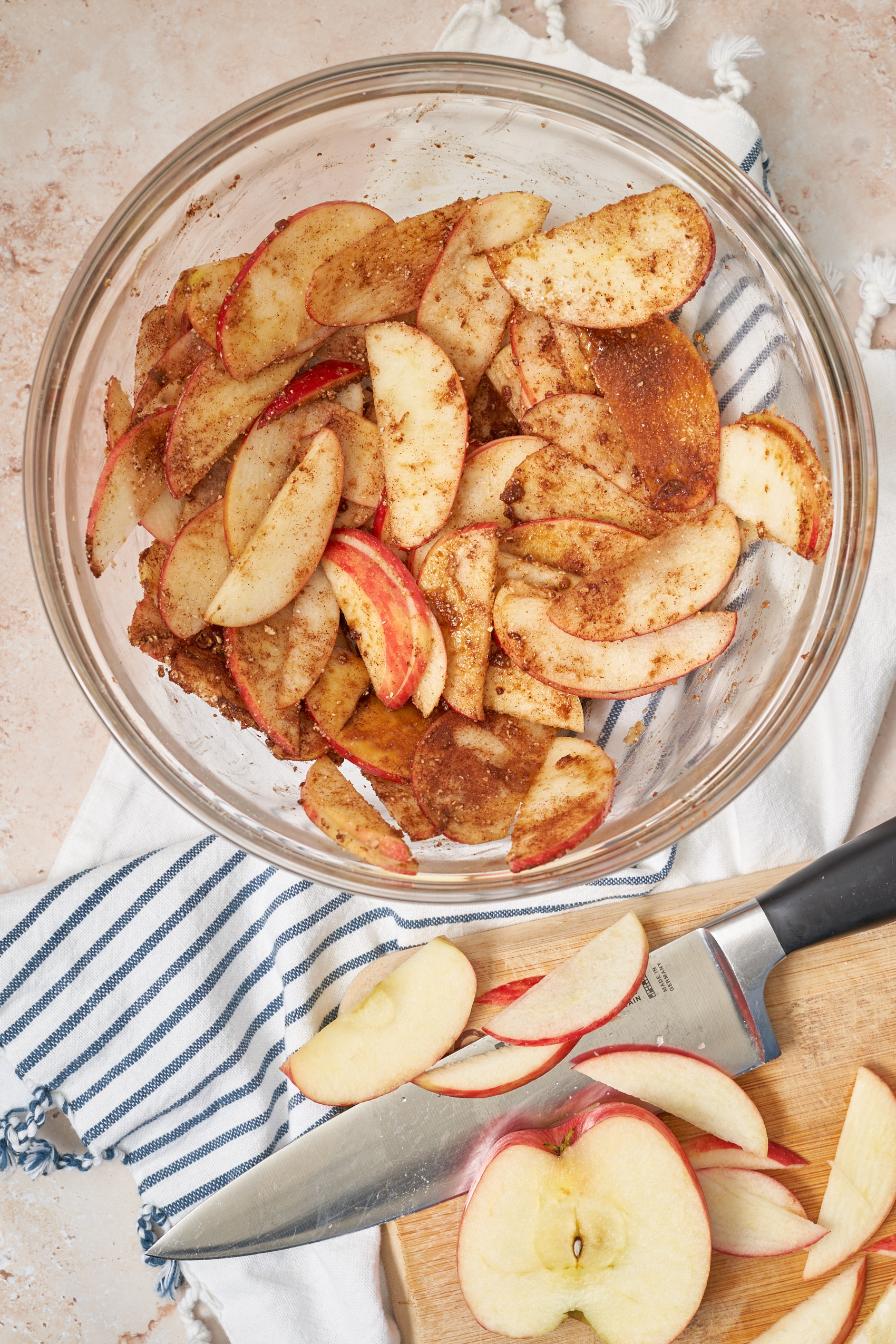 a bowl of thinly sliced apples sprinkled with cinnamon